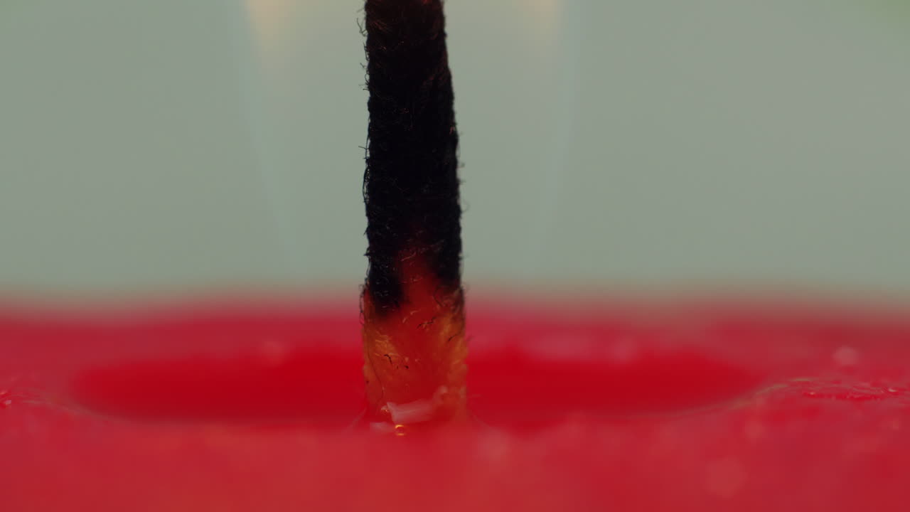 시간 경과:뜨거운 심지에 떨어지는 뜨거운 녹는 밀랍의 매크로 스튜디오 보기