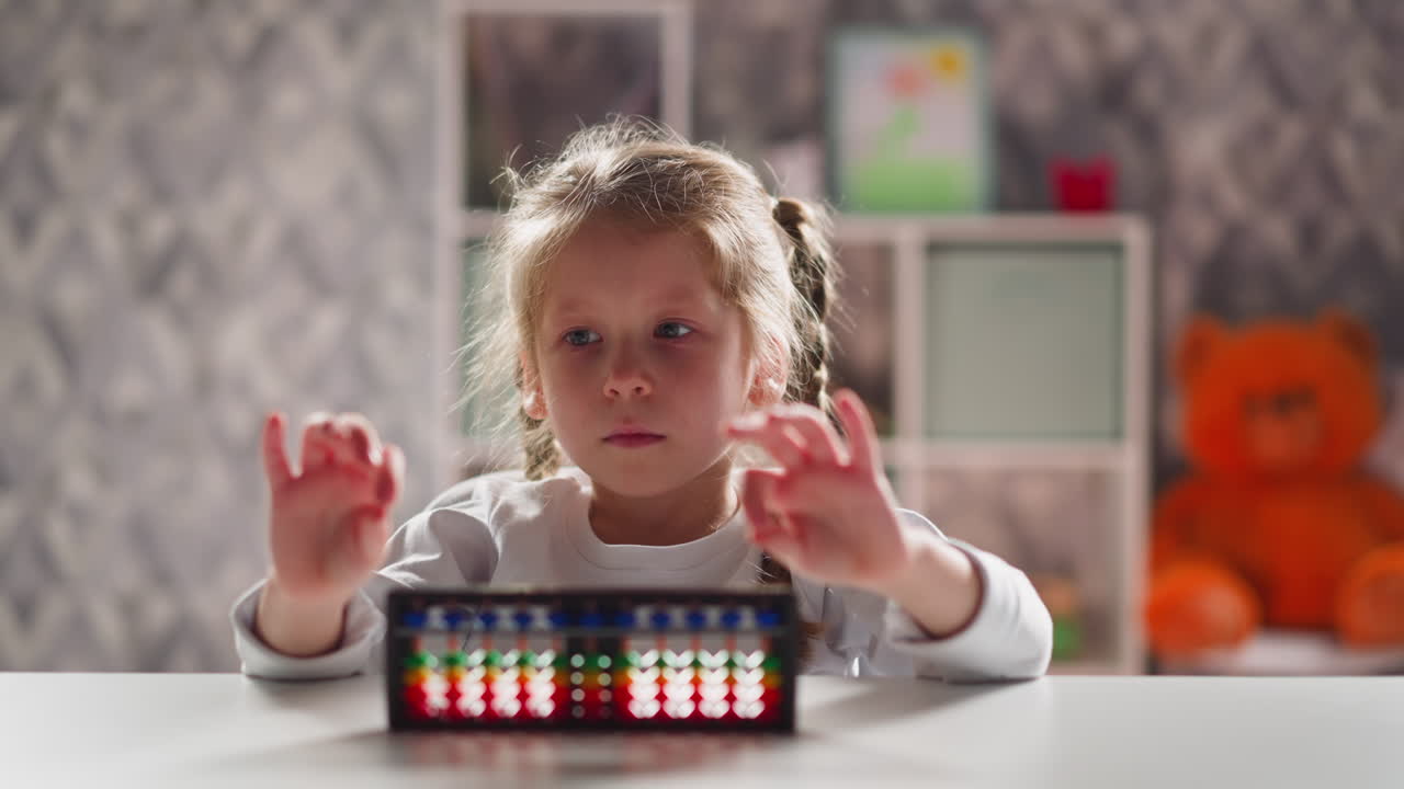 Unhappy little girl does finger training near abacus at desk