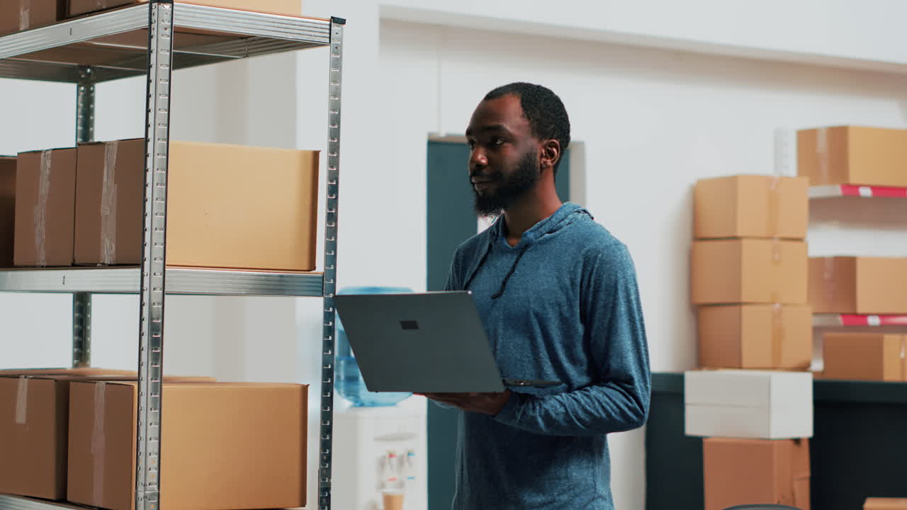Man checking inventory with laptop in warehouse