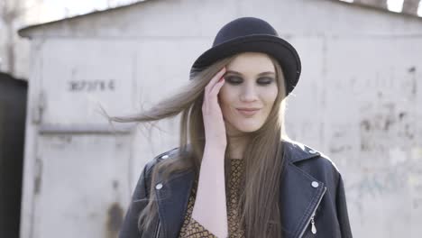 mujer elegante con sombrero negro y chaqueta de cuero