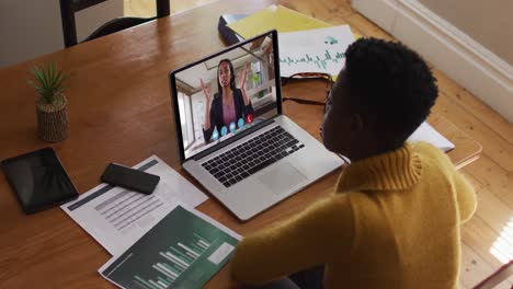 African-american-woman-using-laptop-on-video-call-with-female-colleague-working-from-home