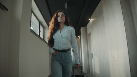 Arrogant-woman-with-suitcase-going-corridor.-Girl-looking-around-in-hotel