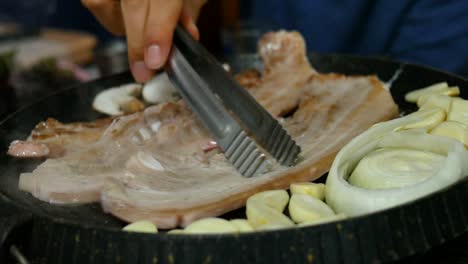 Pork-belly-barbecued-Korean-style-on-a-frying-pan-with-mushrooms,-onions---garlic