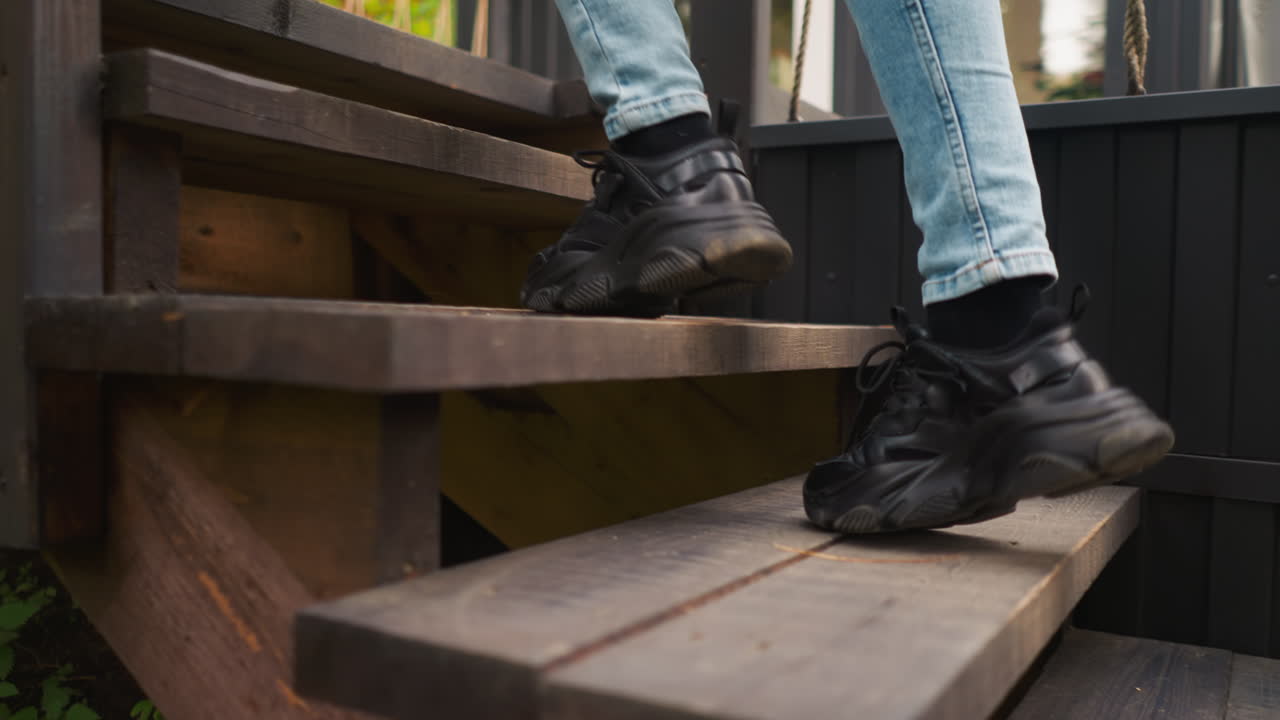 mujer en puntas de pies en las escaleras a la casa de glamping. dama camina a la puerta principal de la cabaña de campo después de pasar tiempo al aire libre. ejercicio matutino para la salud