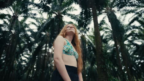 woman in bikini in palm tree forest