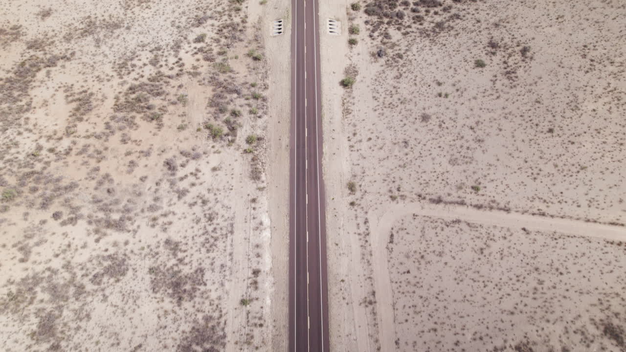 Aerial view of a solo vehicle on an empty stretch of desert highway near Big Bend in west Texas