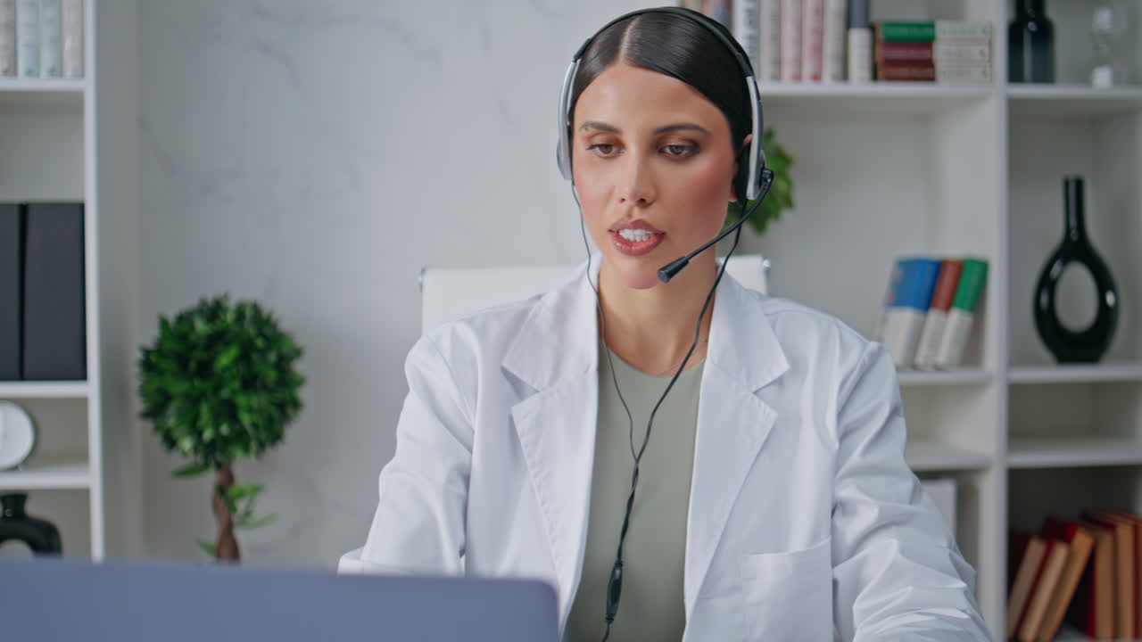 Doctor headset listening patient attentively looking laptop in clinic closeup
