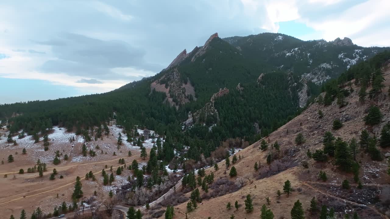 A sweeping drone view of Boulder Flatirons, sprawling hills and iconic rock formations