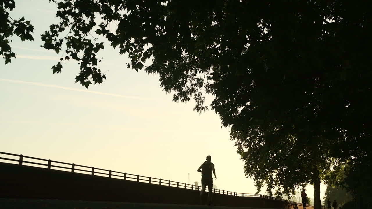 Siluet Gerakan Lambat Pria Berolahraga dengan Joging di Luar Ruangan Saat Fajar - Lockdown Static
