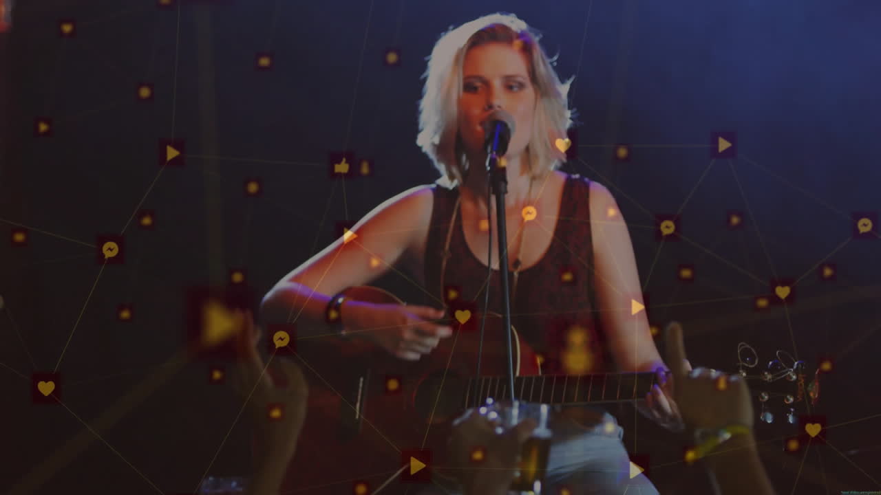 Musician strumming guitar, singing into microphone at music concert with floating icons and phones