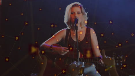 musician strumming guitar, singing into microphone at music concert with floating icons and phones