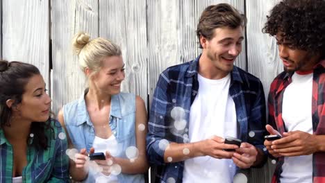 friends using their mobile phones surrounded by white bubbles effect