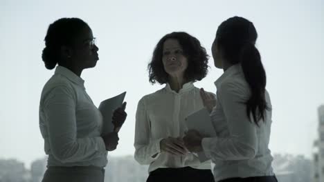 cheerful multiethnic businesswomen shaking hands