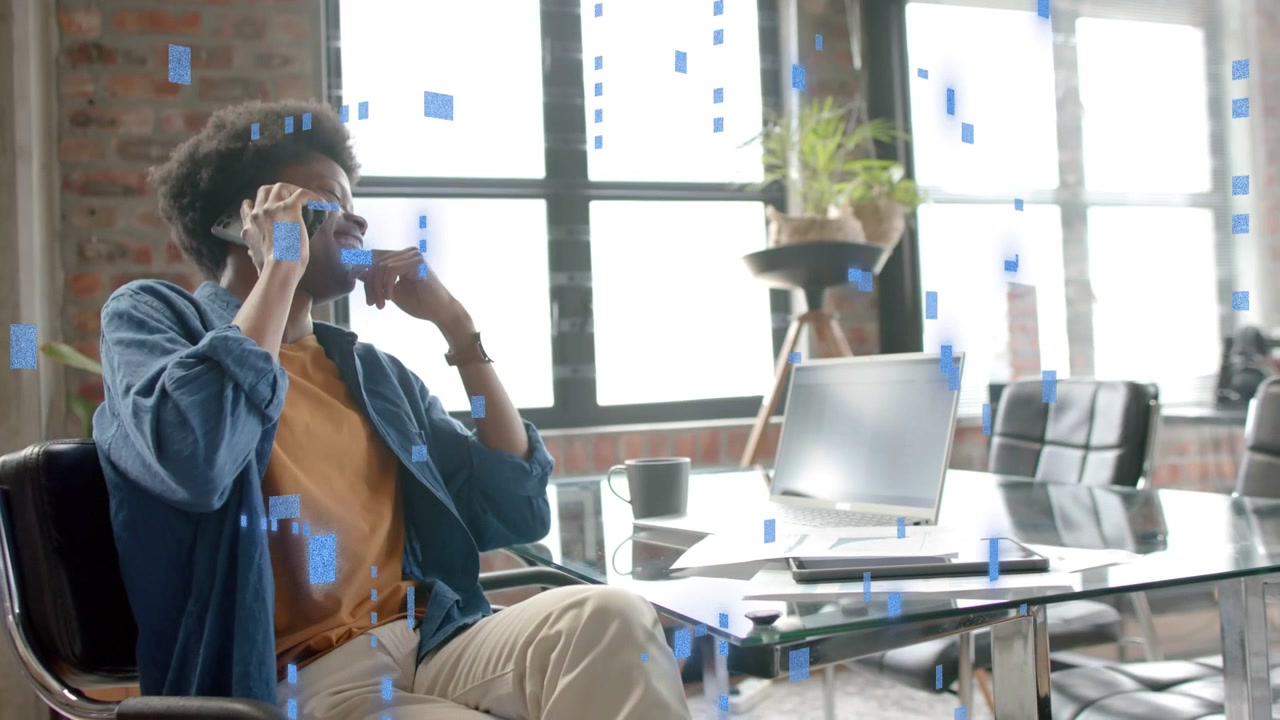 Man answering business call holding phone, leaning back laughing with blue squares overlaying