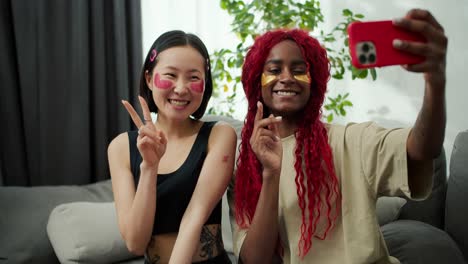 two young beautiful multiethnic women with patches under their eyes posing for selfie photo