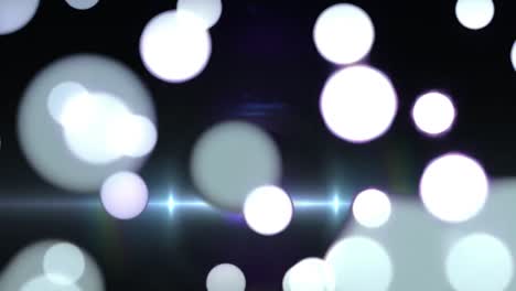 manchas blancas brillantes de luz y destello de la lente contra un fondo negro