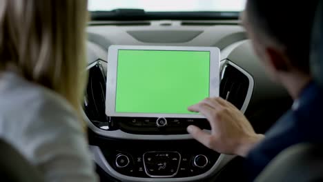 the manager show the information on tablet about car to the businesswoman