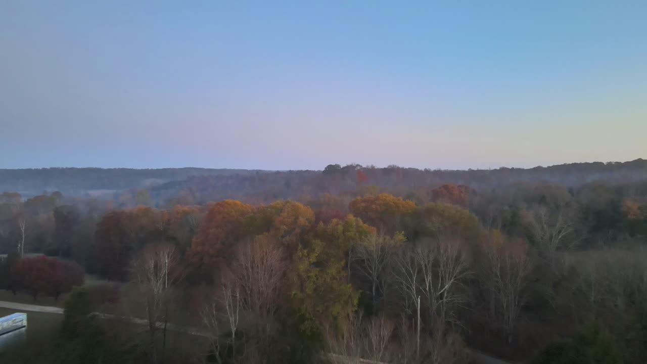 Flying low over beautifully colored autumn treetops in the country