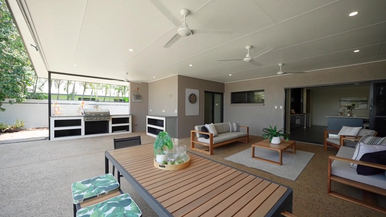 Spacious modern patio with stylish outdoor furniture, surrounded by tropical landscaping.