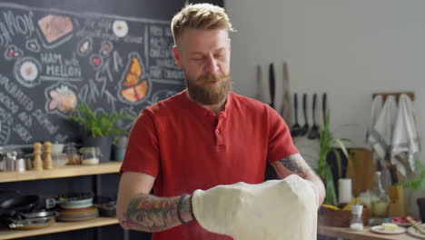 food blogger holding pizza dough and speaking on camera