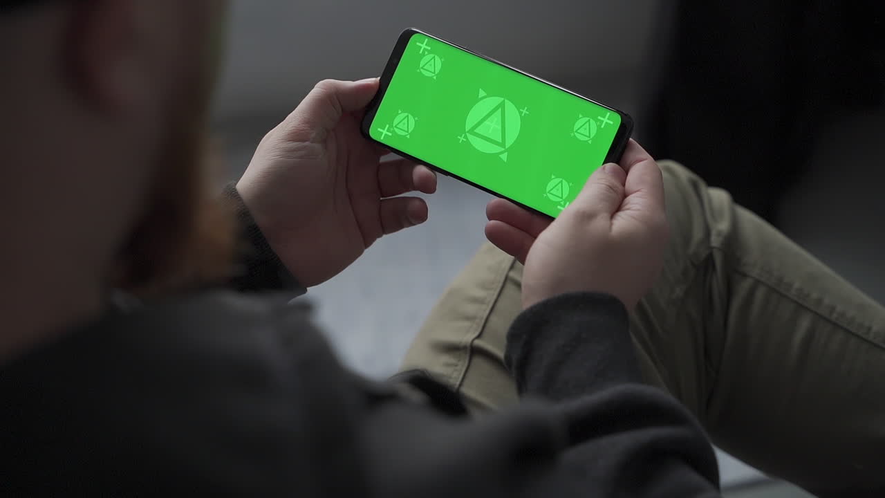 Man holding smartphone with horizontal green screen chroma. Mockup.