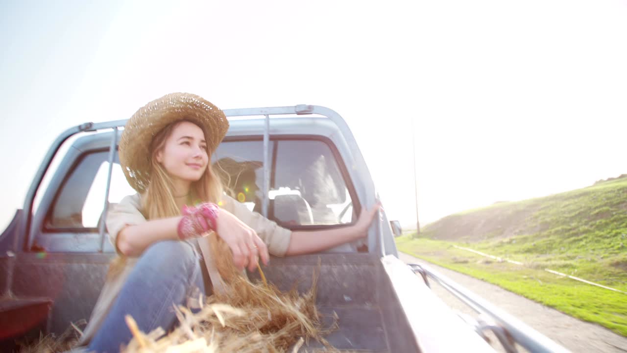 молодая женщина, путешествующая на задней части пикапа.