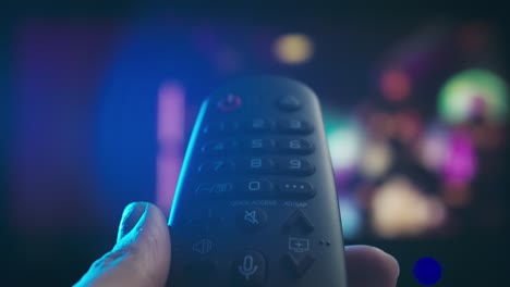 mano con un control remoto de la tv