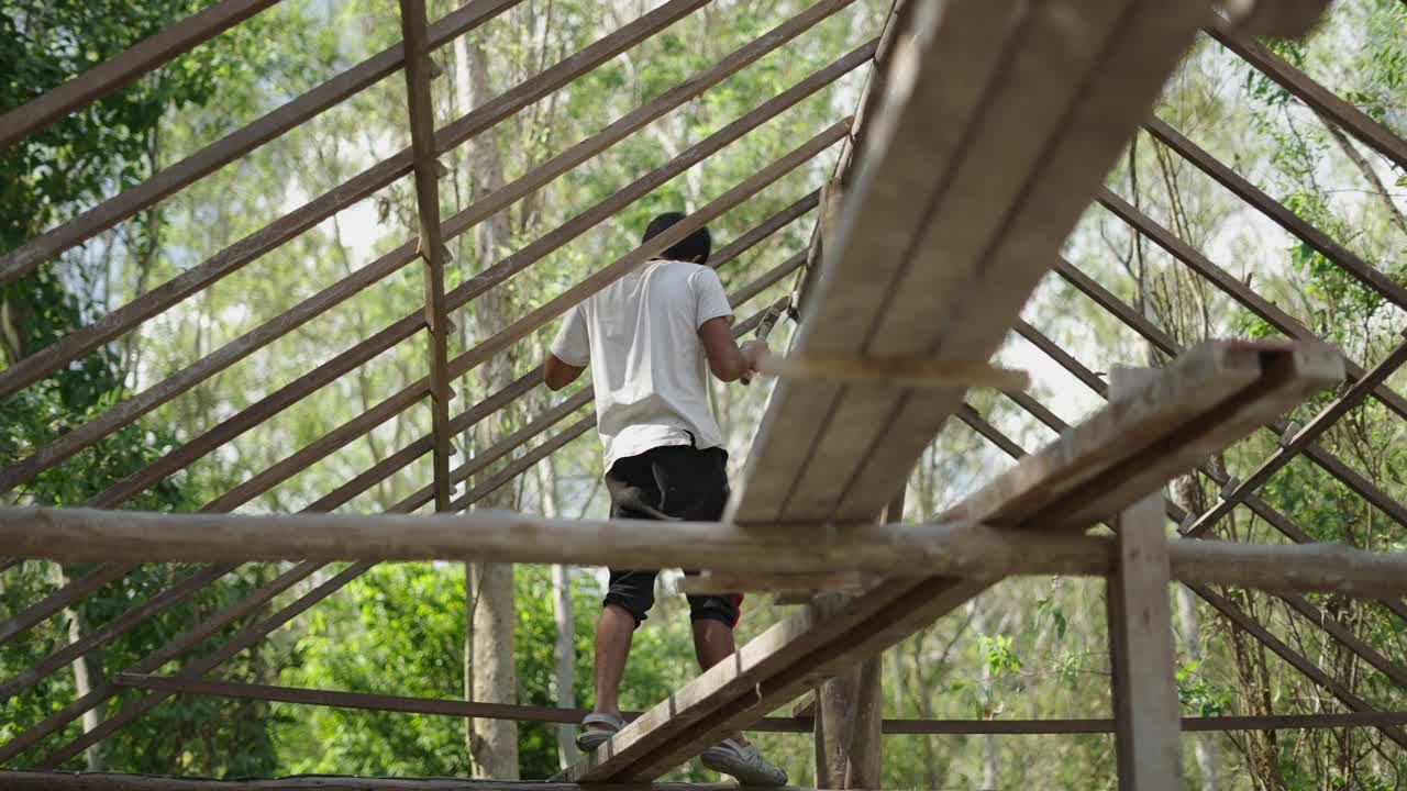 Man working on a wooden roof frame outdoors