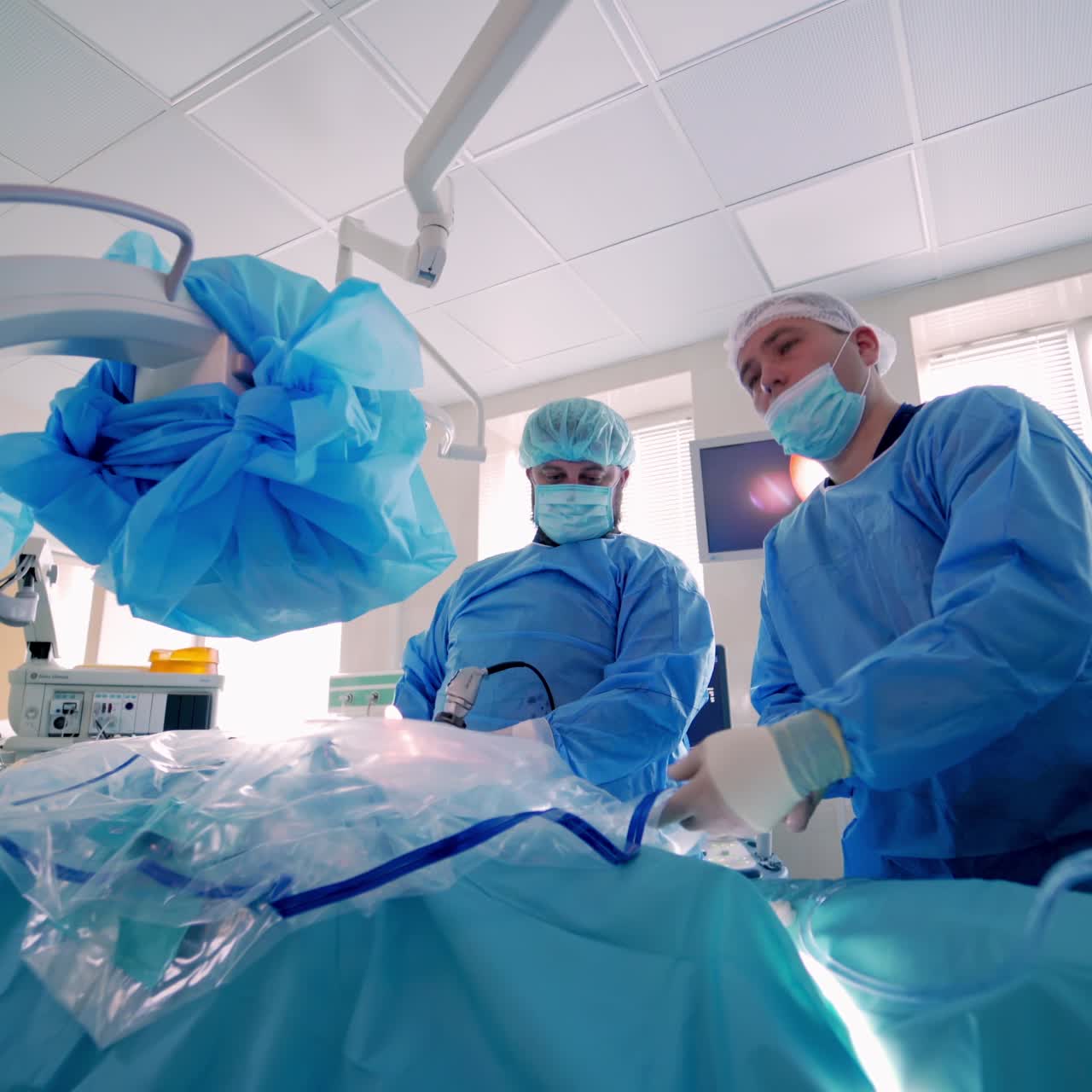 Group of surgeons in operating room with surgery equipment. Modern equipment in operating room.