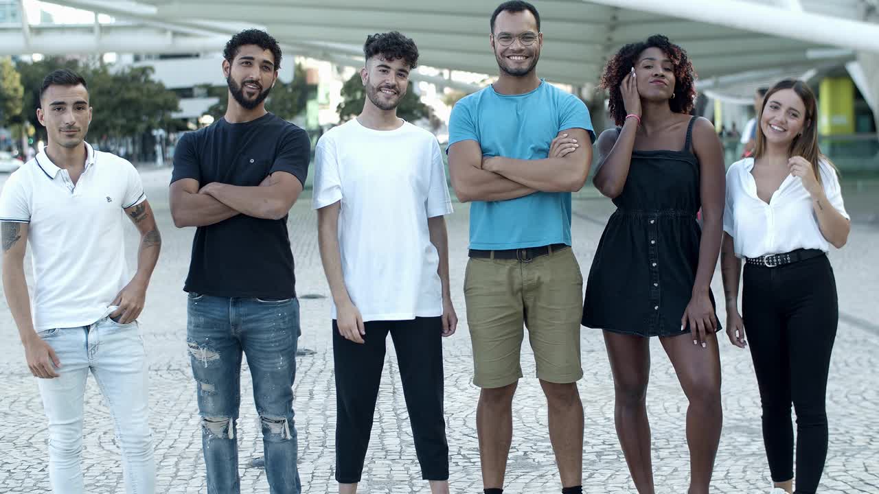 Amigos alegres em pé na rua, em fila