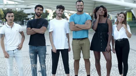 cheerful friends standing on street in row