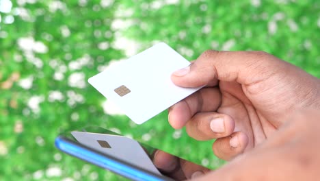 person using a credit card with their smartphone for mobile payment