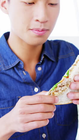 hombre comiendo sándwich con las manos
