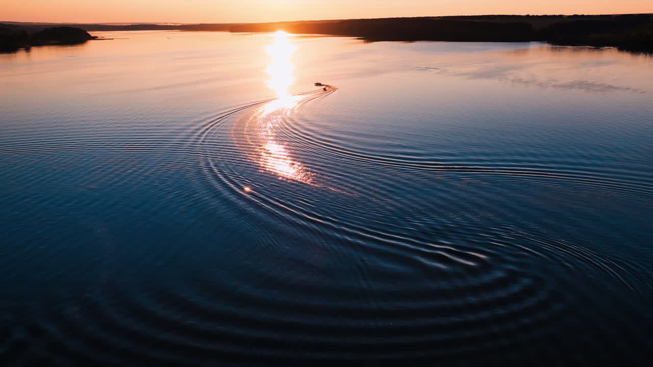 Boat on beautiful river at sunset. Moving boats against the golden path from the evening sun. Aerial view.
