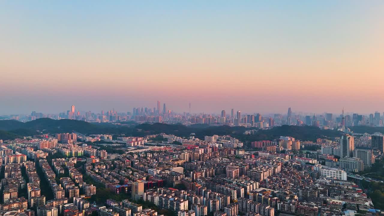 Establishing drone shot of Guangzhou City cityscape and skyline at sunset in Guangdong, China