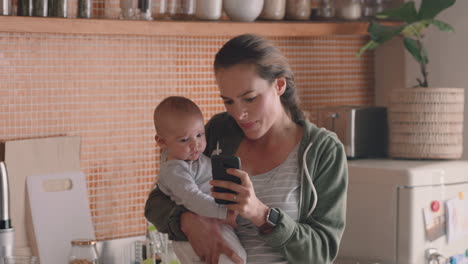 Madre-Joven-Mostrando-Entretenimiento-Con-Teléfono-Inteligente-Al-Bebé-Que-Distrae-Al-Niño-En-Casa