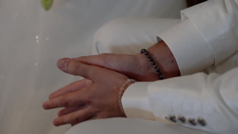 close-up of a groom's hands with bracelets
