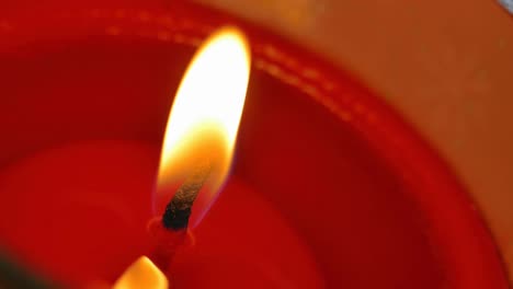 candlelight, the red wax candle with small fire in a slight breeze