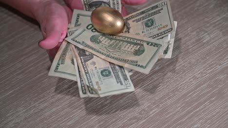 elderly female hands move forward showing a nest of cash while four golden eggs drop into the cash nest symbolizing financial goals that fell into place