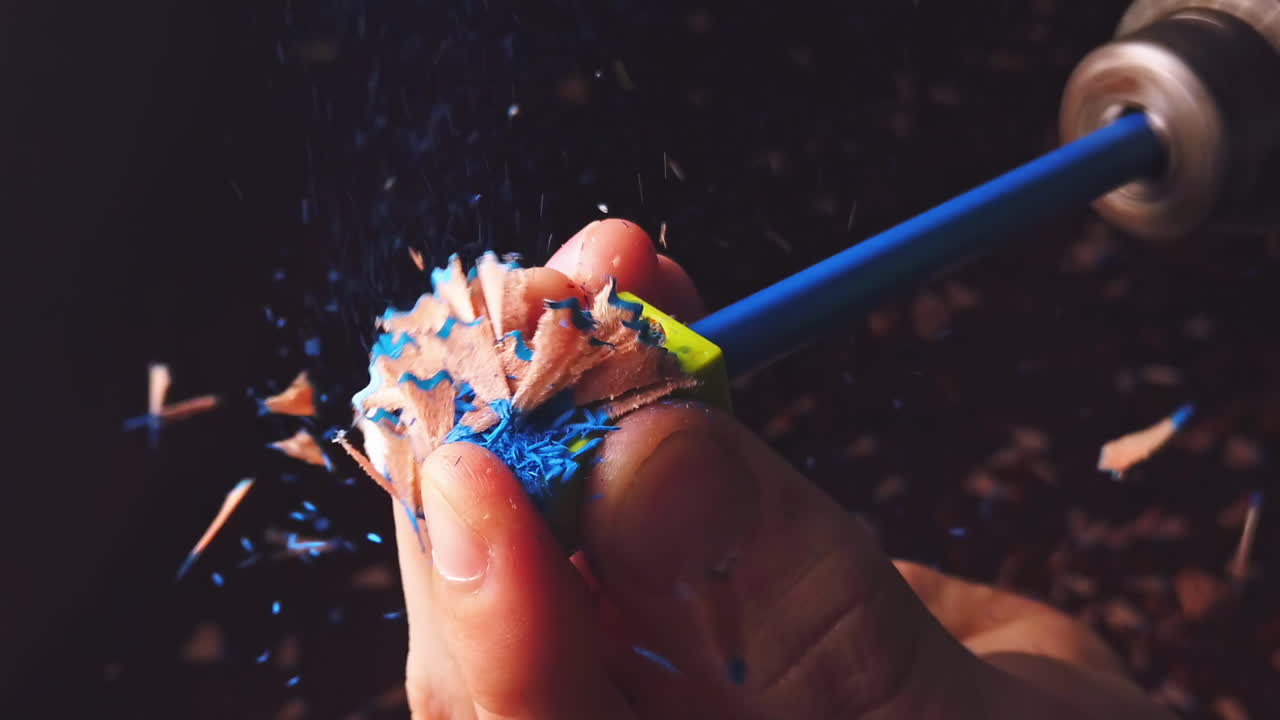 Overhead slow motion of sharpening the pencil in sharpeners using a drill by a caucasian young man