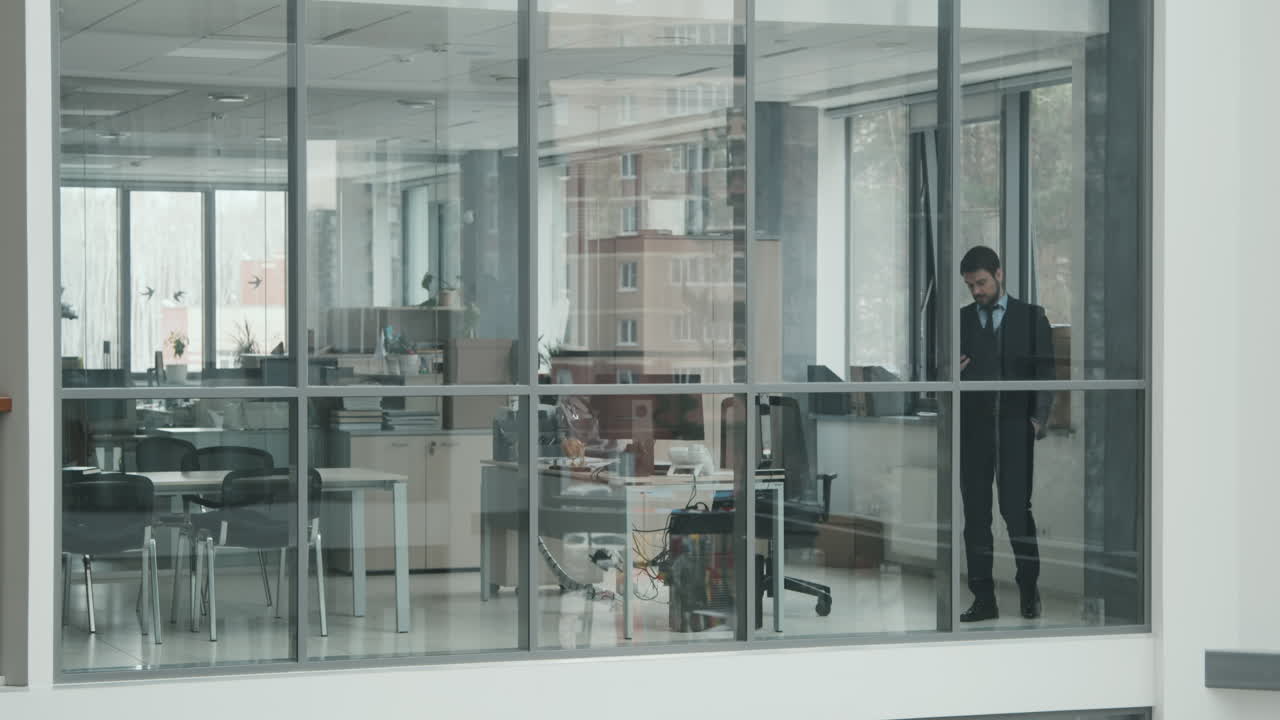Male Lawyer Walking along Glass Office Room