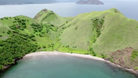 Aerial pan of vibrant tropical coastline on a Costa Rica island, surrounded by lush hills and sea