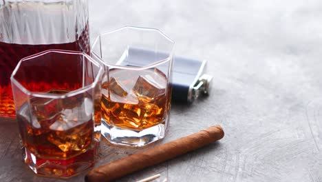 Two-glasses-of-old-whiskey-with-cuban-cigar-and-carafe