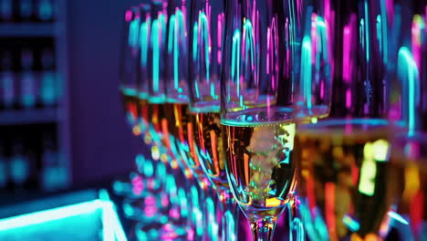 champagne glasses under neon lights