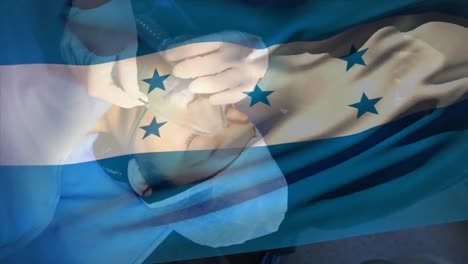 animation of waving honduras flag against doctor placing oxygen mask on a female patient at hospital