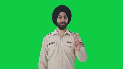 happy sikh indian police man showing victory sign green screen