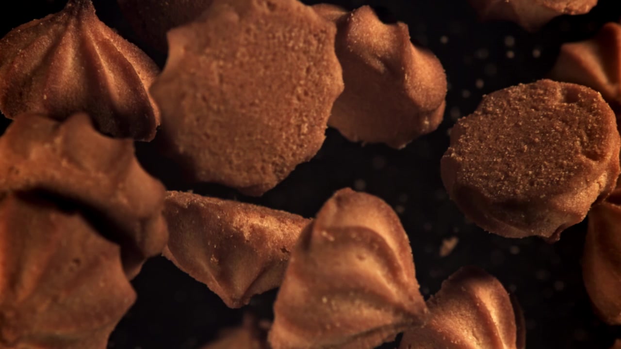Biscotti dorati che cadono al rallentatore con briciole