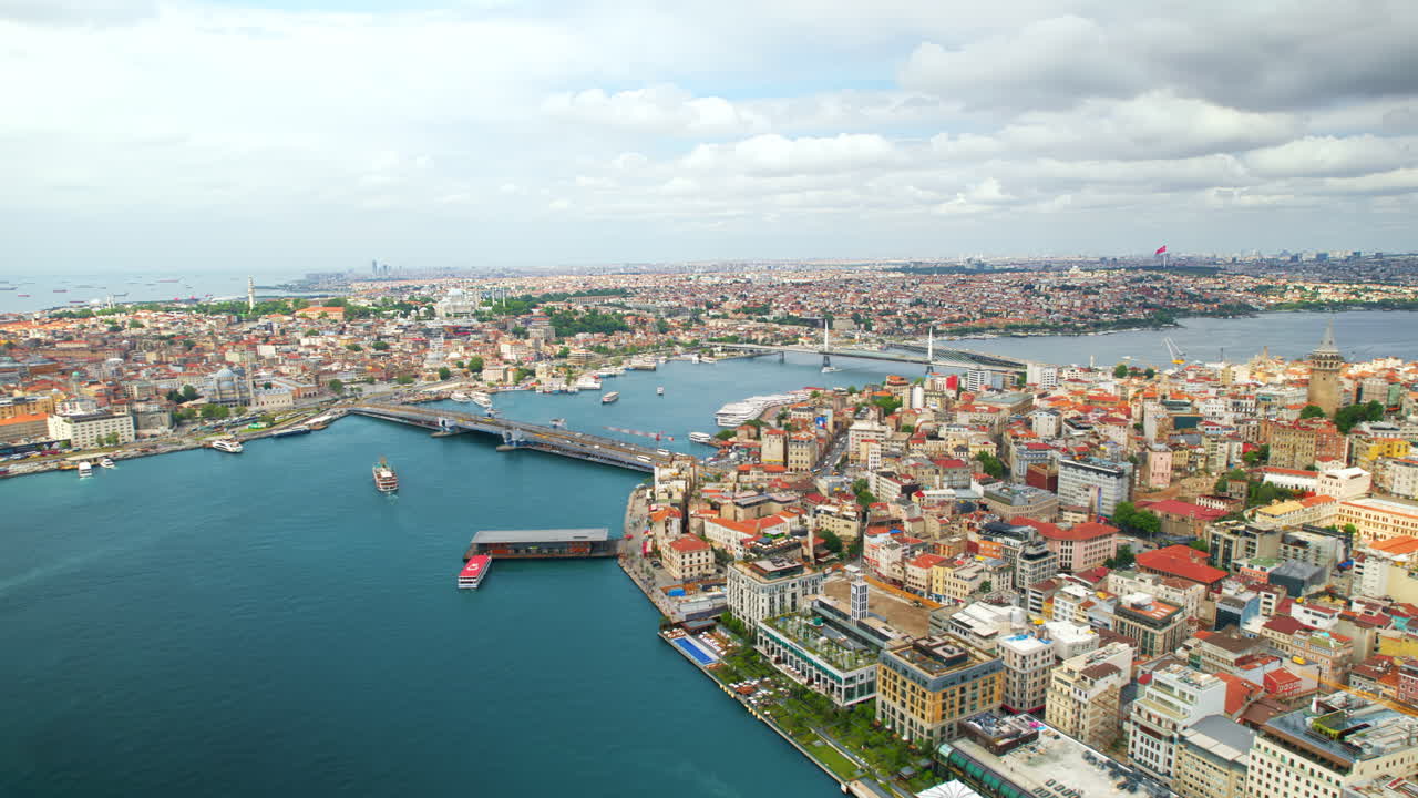 Aerial drone view of Istanbul, Turkey. Multiple residential buildings, mosques, Galata and Metro bridges over the Golden Horn waterway with multiple floating ships
