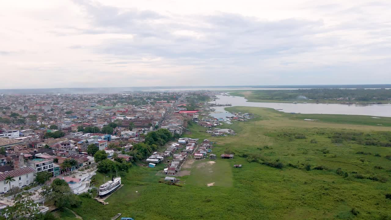 Boats and Riverside Houses Line the Pier in Iquitos, Peru - Aerial Drone Shot