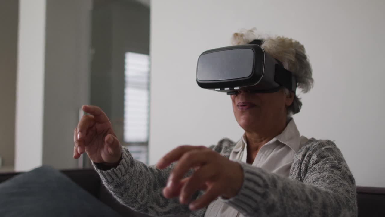 African american senior woman gesturing while wearing vr headset at home
